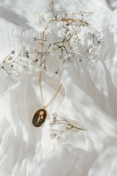Gold necklace with a pendant on a white fabric background